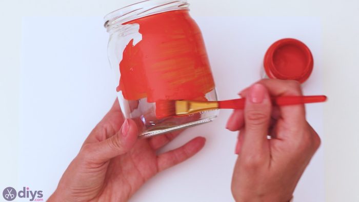 orange paint applied to clear candle jar
